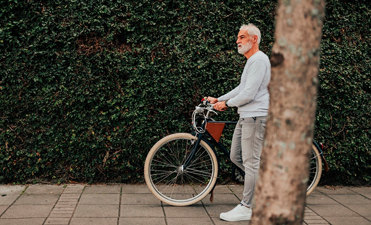 Homem sênior andando de bicicleta pelo bairro Batel